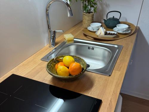 a sink with a bowl of oranges on a counter at Camping maeva Escapades Domaine de la Vingeanne in Longeau