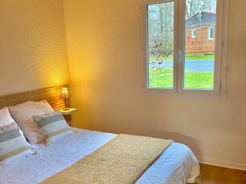 a bedroom with a bed and a window at Camping maeva Escapades Domaine de la Vingeanne in Longeau