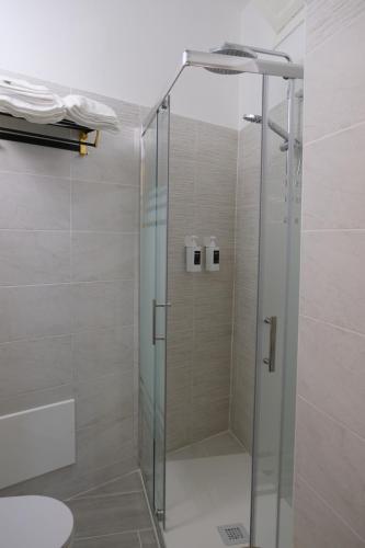 a shower with a glass door in a bathroom at Nel Corso del Sogni Sicily Center Rooms in Campofelice di Roccella