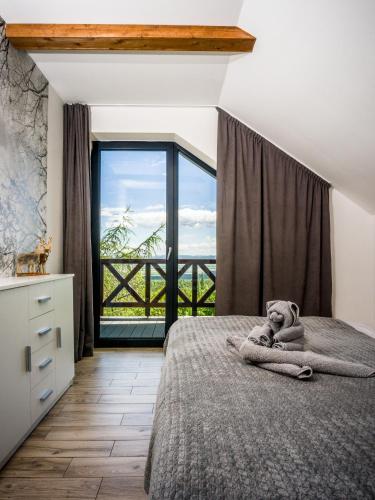 a bedroom with a teddy bear laying on a bed at Hellene Snow Starý Smokovec in Starý Smokovec