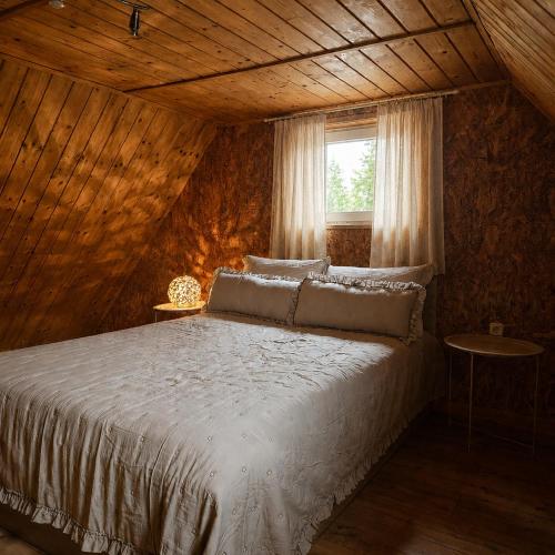 a bedroom with a white bed with a window at Country house in nature -10 min from Nikola Tesla Memorial Center-peace and privacy in Klanac