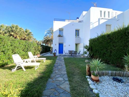 a garden with two chairs and a house at Playa de Baria I in Vera