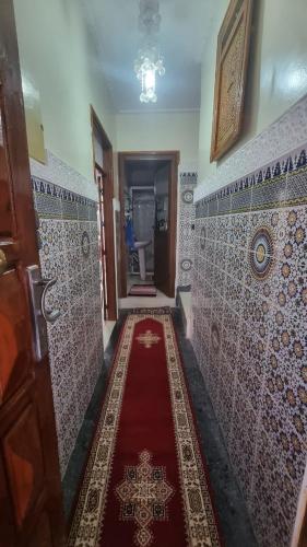 a hallway with a red carpet in a bathroom at Gite El Menzeh in Moulay Idriss