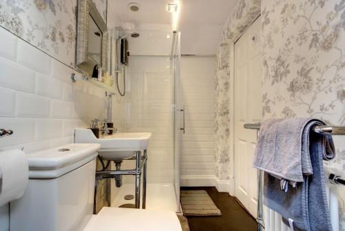 a bathroom with a sink and a toilet and a shower at Carnegie Library: Bronte Apartment 1 Bedroom in Swinton