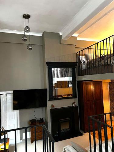 a living room with a fireplace and a flat screen tv at Carnegie Library: Bronte Apartment 1 Bedroom in Swinton