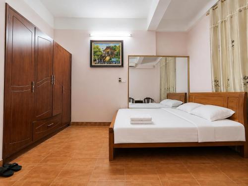 a bedroom with a bed and a large mirror at Hisun Hotel Quốc tế - Đông Anh in Thụy Ha