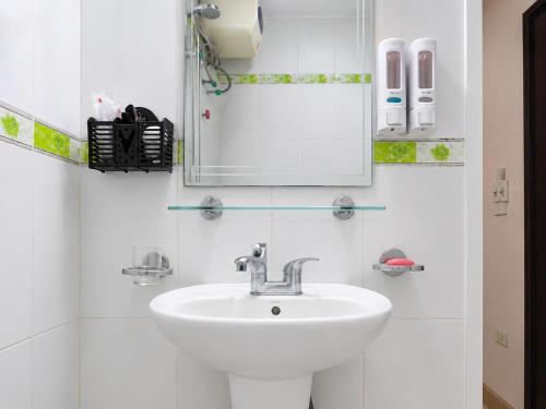 a white bathroom with a sink and a mirror at Hisun Hotel Quốc tế - Đông Anh in Thụy Ha