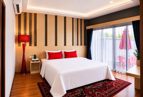 a bedroom with a white bed with red pillows and a window at Villa Escape Aonang Krabi in Krabi