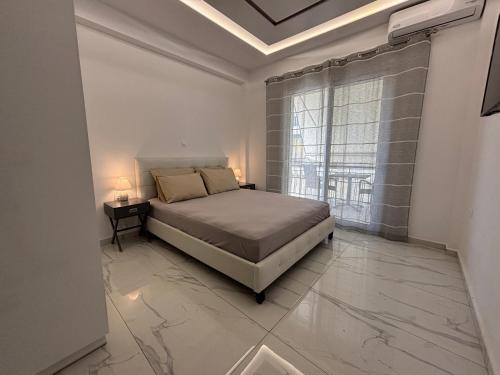 a bedroom with a bed and a large window at The Onyx Residence in Loutraki