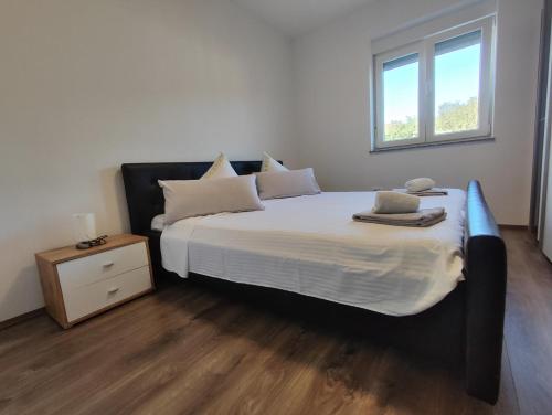 a bedroom with a large bed with white sheets and pillows at Kata 2 in Ližnjan