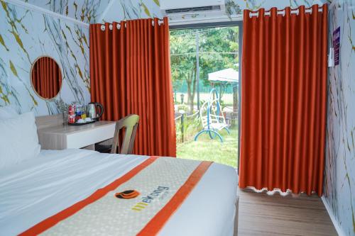 a bedroom with a bed and a desk and a window at Mekong Hotel in Tây Ninh