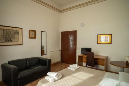 a living room with a couch and a bed and a desk at Casa di Alfredo Affittacamere in Siena