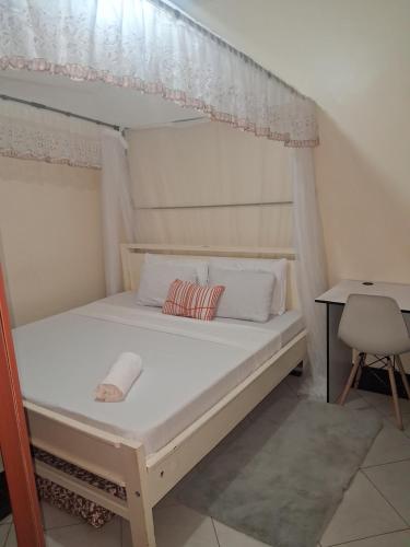 a bed in a room with a white bed frame at Shalom - Stays in Voi