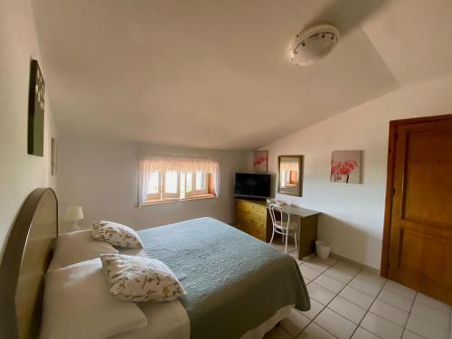 a bedroom with two beds and a desk and a television at Casa Mare Holiday Pozzallo in Pozzallo