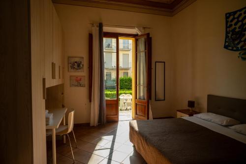 a bedroom with a bed and a table and a window at Casa di Alfredo Affittacamere in Siena