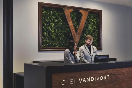two people standing at a reception desk with a laptop at Hotel Vandivort in Springfield