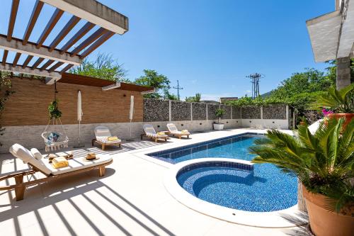 a backyard with a swimming pool and chairs and a patio at Villa D Apartments in Podlastva