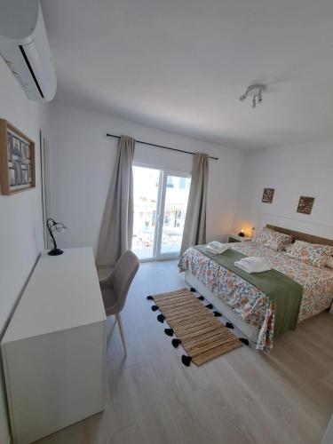 a bedroom with a bed and a desk and a window at Davinia apartamento centro in Nerja