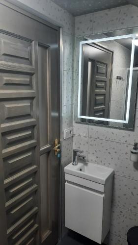 a bathroom with a toilet and a sink and a mirror at Garage Home in Yaremche
