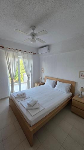 a bedroom with a large bed with white sheets at Bright & Bloom maisonette in Hanioti