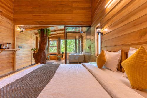 a large bed in a room with wooden walls at Echor Malusara Lakeview Retreat Bhimtal in Bhīm Tāl