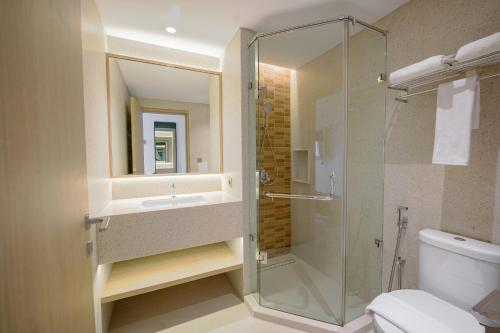 a bathroom with a shower and a sink and a toilet at Kotta Kyu Hotel Semarang in Semarang