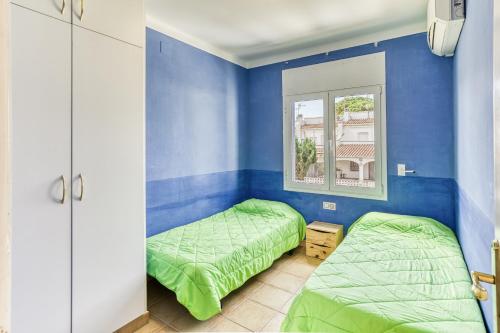 a bedroom with two beds and a window at Apartamento Girelle in L'Escala