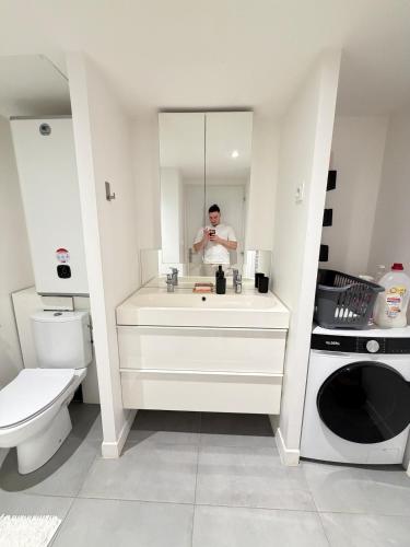 a man taking a picture of himself in a bathroom mirror at Douceur Suite - 2 bedrooms in Mâcon