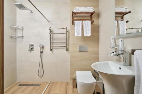a bathroom with a sink and a toilet and a shower at Arda Karvon Saroy in Khiva