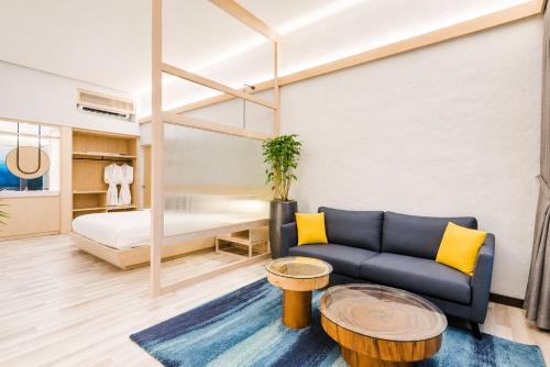a living room with a couch and a bed at Tien Hotel Georgetown in George Town