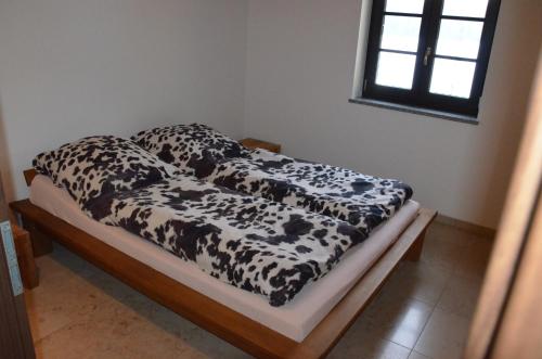 a black and white blanket on a bed in a room at Ferienwohnung Emmert Landshut in Landshut