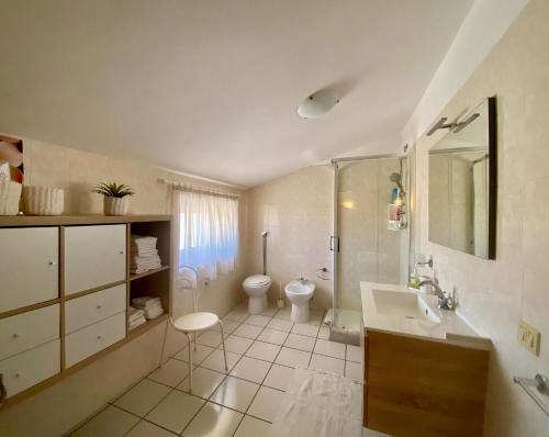 a bathroom with a toilet and a sink and a shower at Casa Mare Holiday Pozzallo in Pozzallo