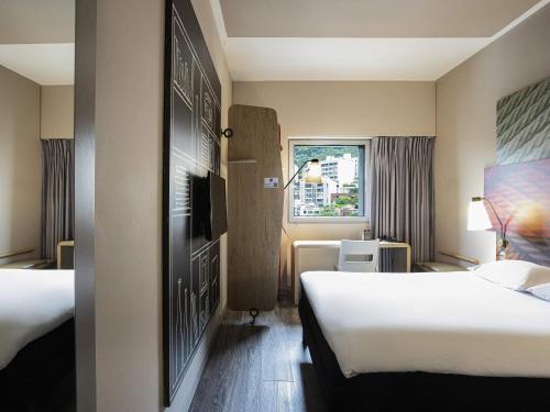 a hotel room with two beds and a window at Hotel Ibis Cali Granada in Cali