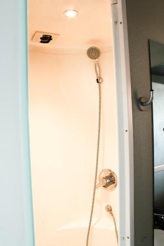 a shower in a bathroom with a shower head at ibis budget Saint-Omer Centre in Saint-Omer