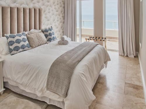 a bedroom with a white bed with a view of the beach at Unit 1101 Oyster Rock in Durban