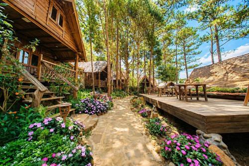 a garden with flowers in front of a house at Sóc House Măng Đen in Kon Plong