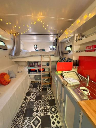 a small bedroom with a bed and a kitchen in a trailer at Solar Powered Hideaway converted horse box in Fishbourne