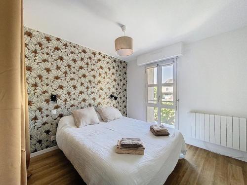 a bedroom with a bed with a floral wall at Appartement 4 personnes in Cholet