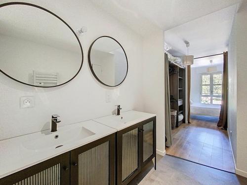 a bathroom with a sink and two mirrors on the wall at Appartement 4 personnes in Cholet