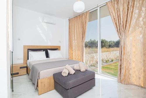 a bedroom with a bed and a large window at Dreamy Charaki 2 Bd Villa with Private Pool in Haraki