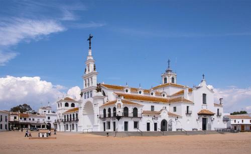 a large white church with a cross on top of it at LolaSuite Confort in El Rocío