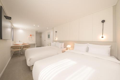 a hotel room with two beds and a table at No25 Hotel Chuncheon Cityhall in Chuncheon