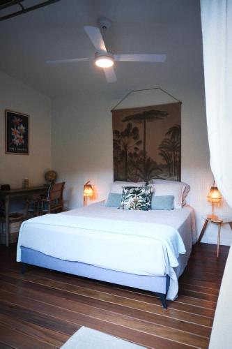 a bedroom with a large white bed in a room at Bungalow l'escapade in Entre-Deux