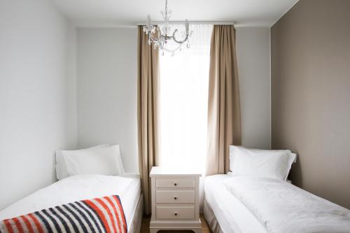 zwei Betten in einem Zimmer mit Fenster in der Unterkunft Hotel Ódinsvé in Reykjavík