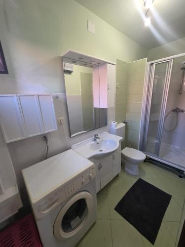 a bathroom with a washing machine and a sink at Brane Apartmani in Zadar