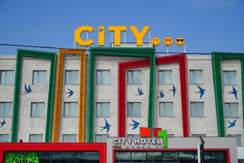 a building with a sign on top of it at City Hotel Shymkent in Shymkent