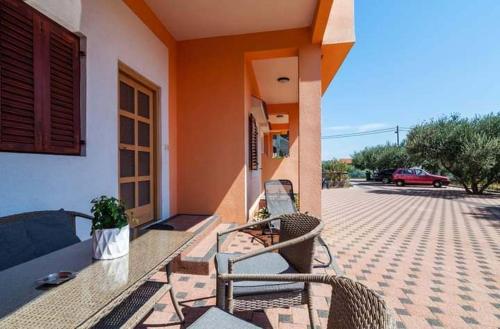 a patio with a table and chairs on a house at Brane Apartmani in Zadar
