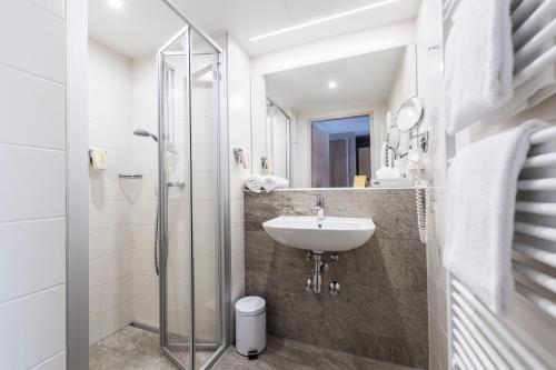 a bathroom with a sink and a shower at JUFA Hotel Grundlsee in Grundlsee