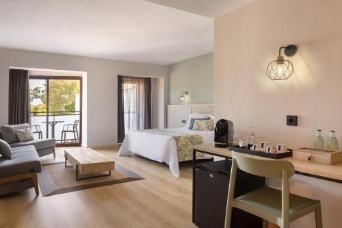 a bedroom with a bed and a desk with a chair at htop Jadhe SPA 4Sup - Bliss in Calella
