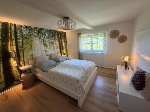 a bedroom with a bed and a large painting on the wall at Ferienhaus am Bächle in Breitnau